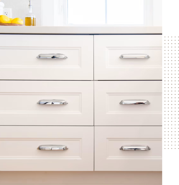 A kitchen with a white counter top and drawers